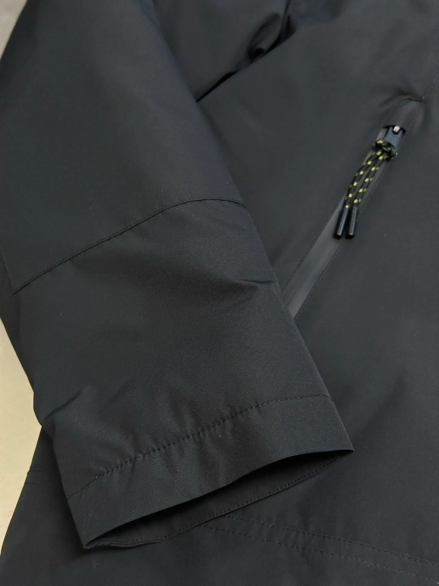 P970 Ralph Lauren logo hooded down jacket. The density of high-density nylon taffeta is about 210T-300T. The surface is smooth and slightly matte. It has excellent windproof and waterproof performance (with DWR water-repellent treatment). It has strong wrinkle resistance and is easy to care for. It is in line with the positioning of American casual "durable and practical".  The inner lining is made of 100% polyamide. The high-density and tight weaving process prevents fine lint from getting out of the gaps in the fabric. The smooth surface improves the putting on and taking off experience, and the excellent wear and tear resistance ensures damage caused by frequent use, while the light and soft texture does not affect the overall weight.  It uses 90 white duck down with a weight of 220g to ensure excellent thermal insulation performance. After strict screening and processing, the velvet is not easily drilled, ensuring durability. The classic jacket has a slightly loose fit, with slightly dropped shoulder lines (the shoulder width is 1-2cm wider than the standard fit). The length reaches the hips, and the sleeves are slightly tapered straight sleeves, taking into account freedom of movement and casual style.  The adjustable Velcro on the cuffs allows you to freely adjust the tightness according to the thickness of your wrist and personal preferences, effectively preventing cold wind from intruding, and improving the warmth performance. Two zippered pockets on the front are convenient for placing frequently used items, and the zipper design ensures that items are not easily lost. A built-in pocket on the left side of the chest provides a safe storage space for some small private items.  The drawstring design at the hem allows you to adjust the shape of the jacket according to your body shape and dressing needs. Whether it is loose and casual or slim and neat, you can easily control it.  Polo horse logo on the left chest: flat satin stitch embroidery (satin embroidery), using 100% polyester high color fastness embroidery thread (the color number is consistent with the brand's standard red color card), the stitch density is 12-15 stitches/cm, the outline of the horse logo is clear, and the details of the rider and horse are burr-free. Precise positioning through the template (12cm from the bottom of the collar and 8cm from the placket) ensures symmetry and centering.  size：s m l xl